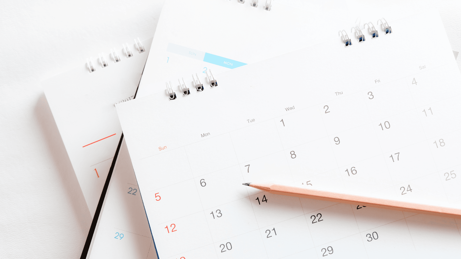 A calendar with a pencil on top of it.